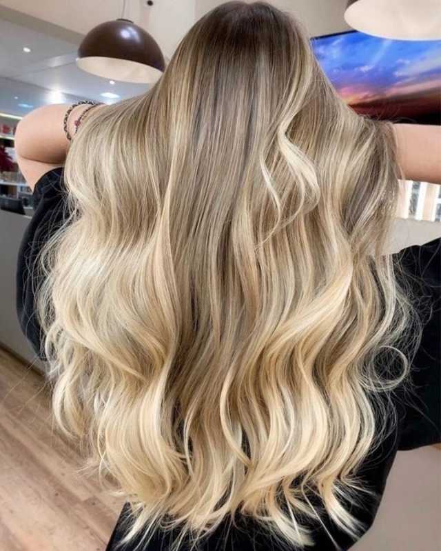 Long, wavy blonde hair with soft highlights.