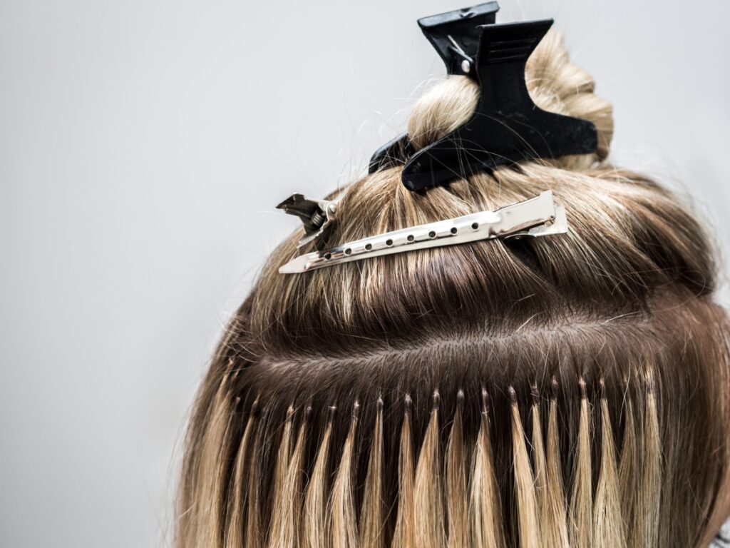 Blonde micro ring extensions being installed