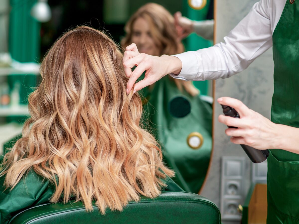 Wavy highlighted hair styled in salon chair